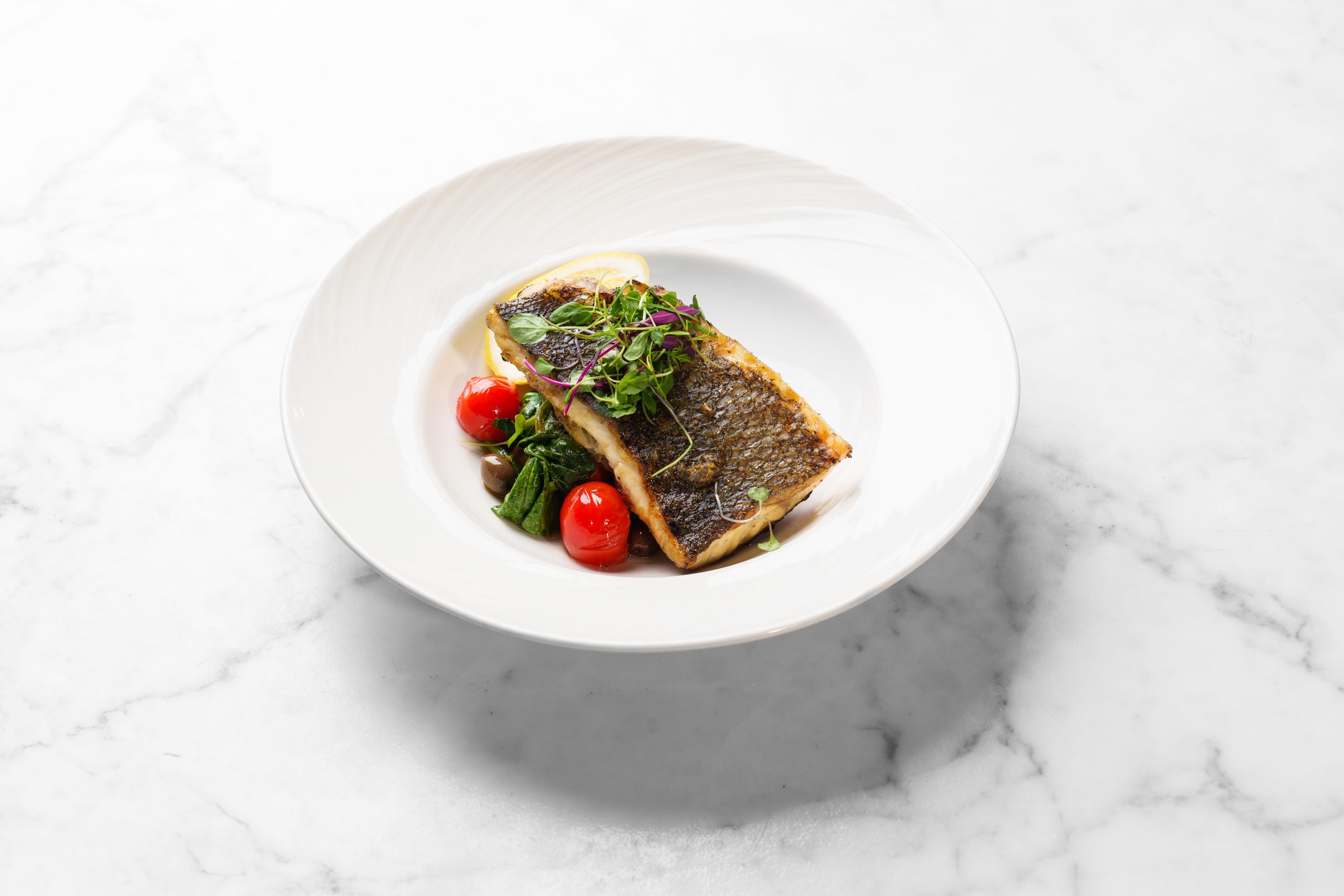 Branzino Filet with Daterrino Tomatoes, Taggiasca Olives & Sautéed Spinach