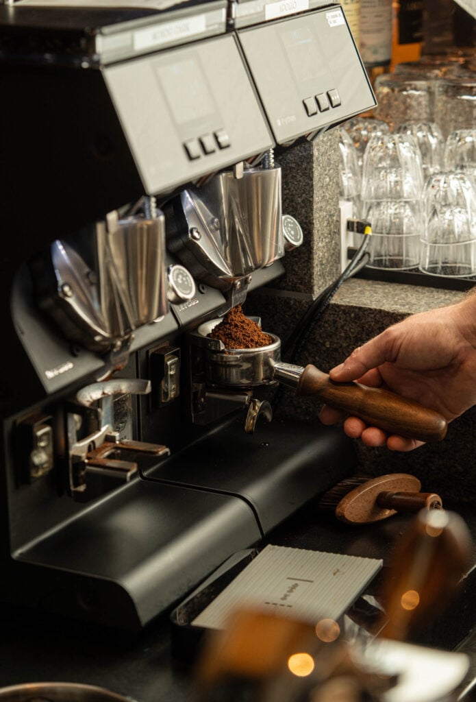 Barista grinding coffee at the coffee bar