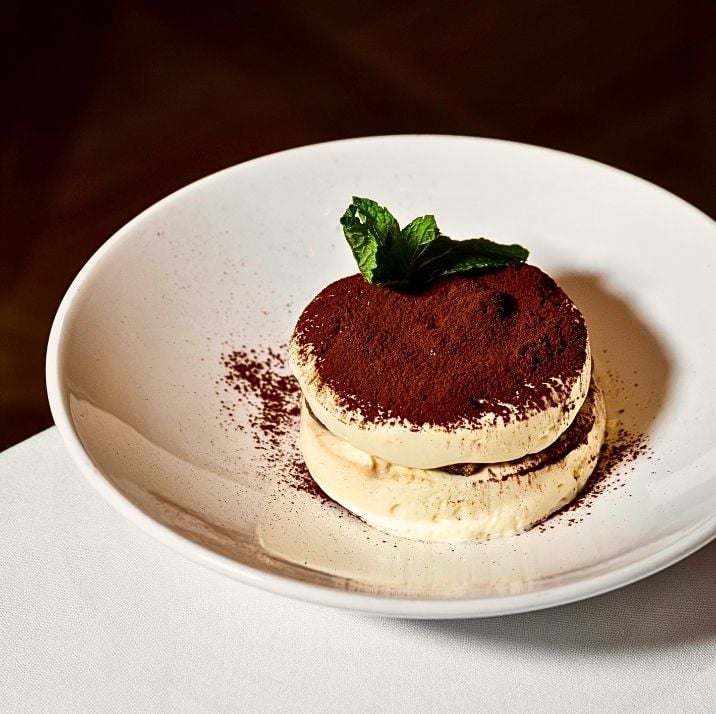 Classic Italian tiramisu dusted with cocoa and topped with mint